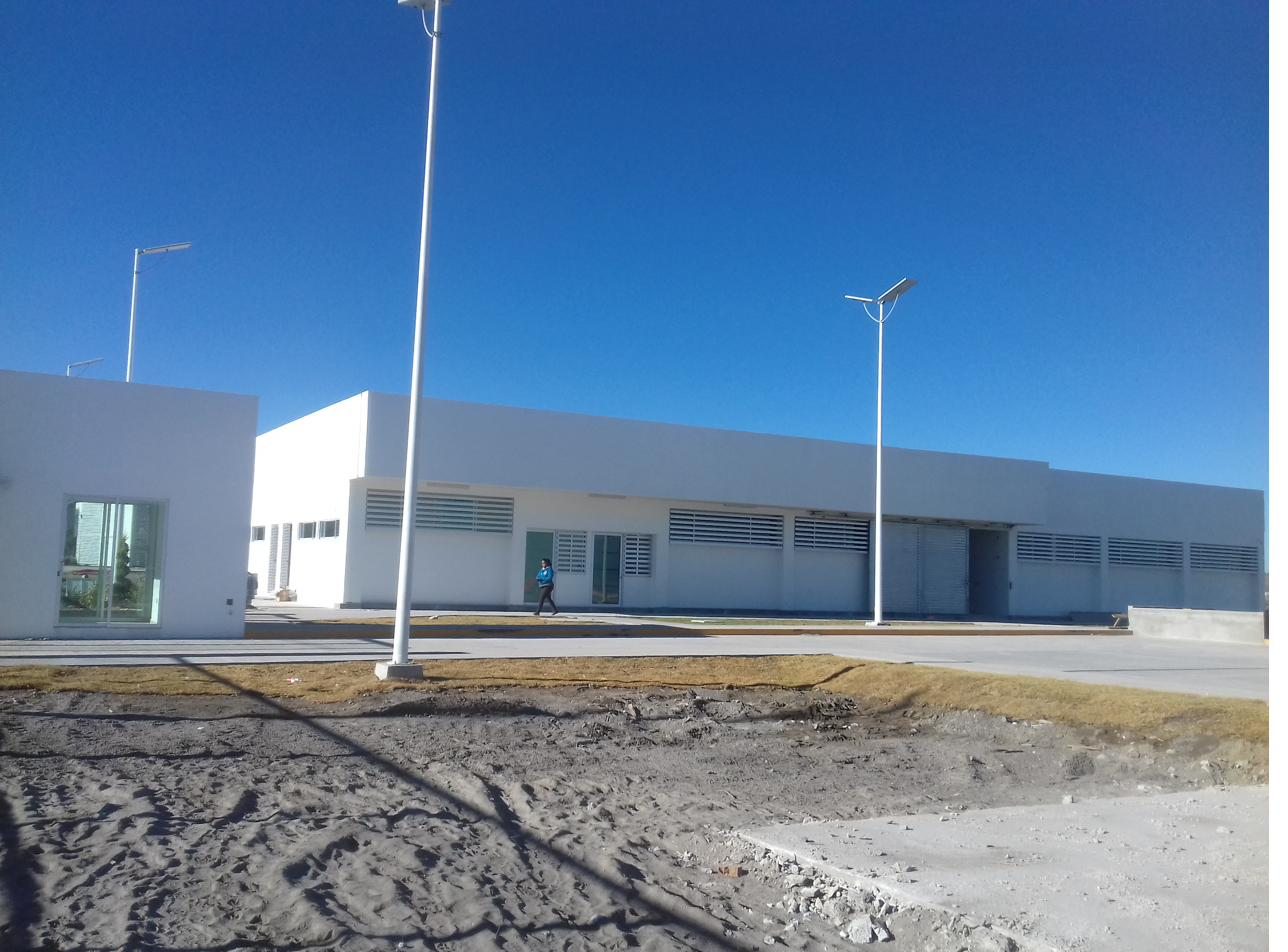 Edificio de servicios con celosías metálicas y luminarias solares